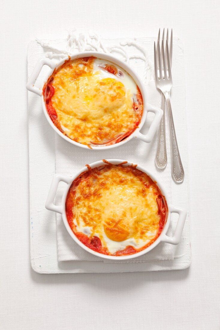 Ham and tomato bake with fried eggs and cheese