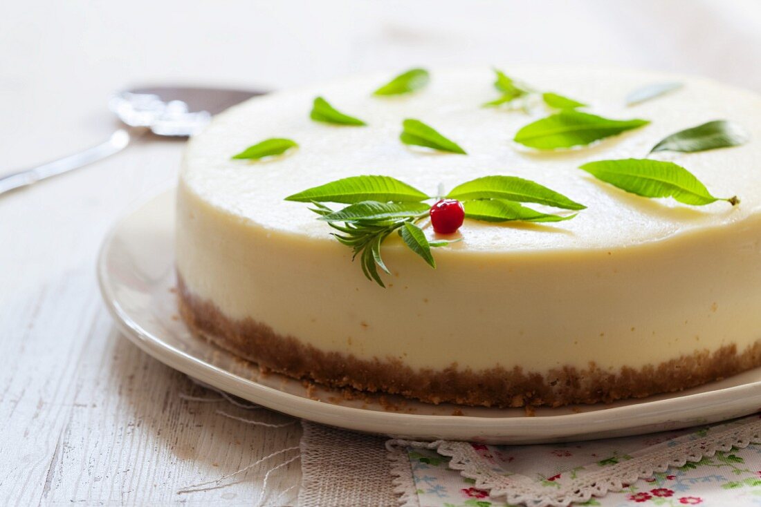 A cheesecake topped with leaves