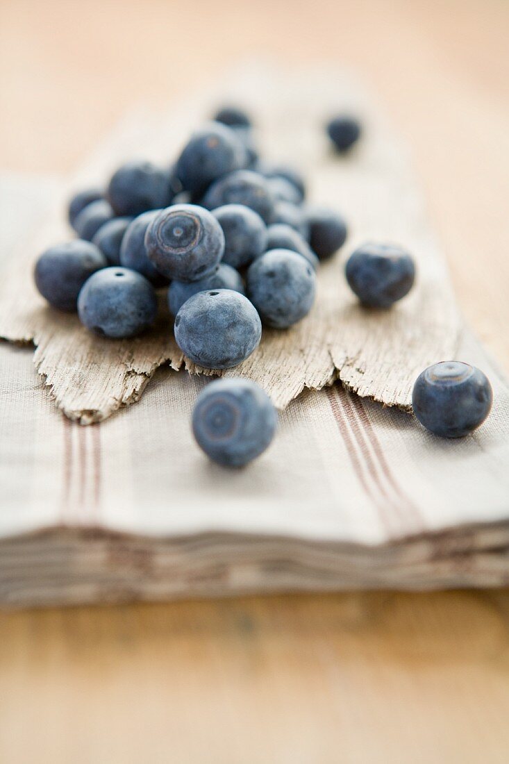 Blueberries on a wooden surface and on a tea towel