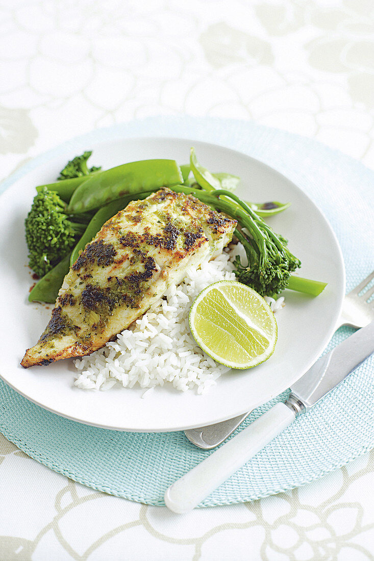 Fish with a green chilli crust on rice and green vegetables