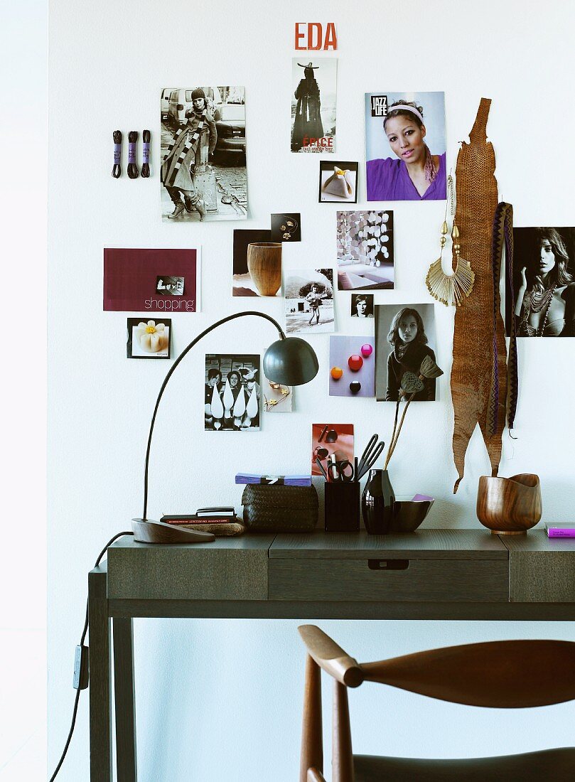 Modern, dark wood desk in front of photos affixed to wall