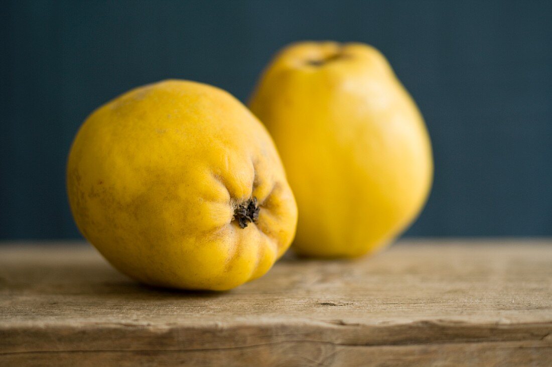 Two quinces on a wooden board