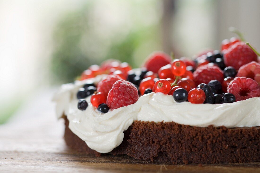 Chocolate cake topped with cream and berries