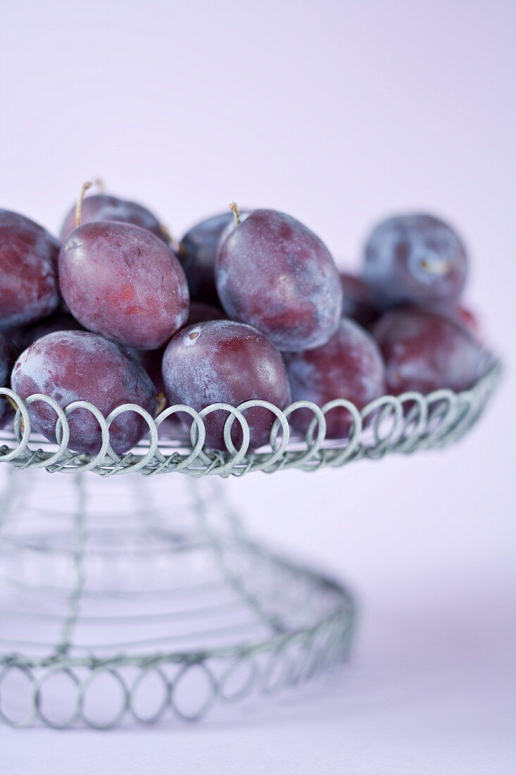 Fresh plums in a wire basket