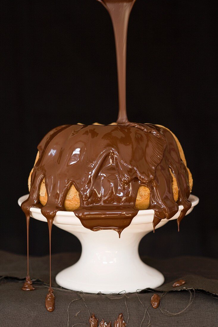 Chocolate glaze being poured over a Madeira Bundt cake