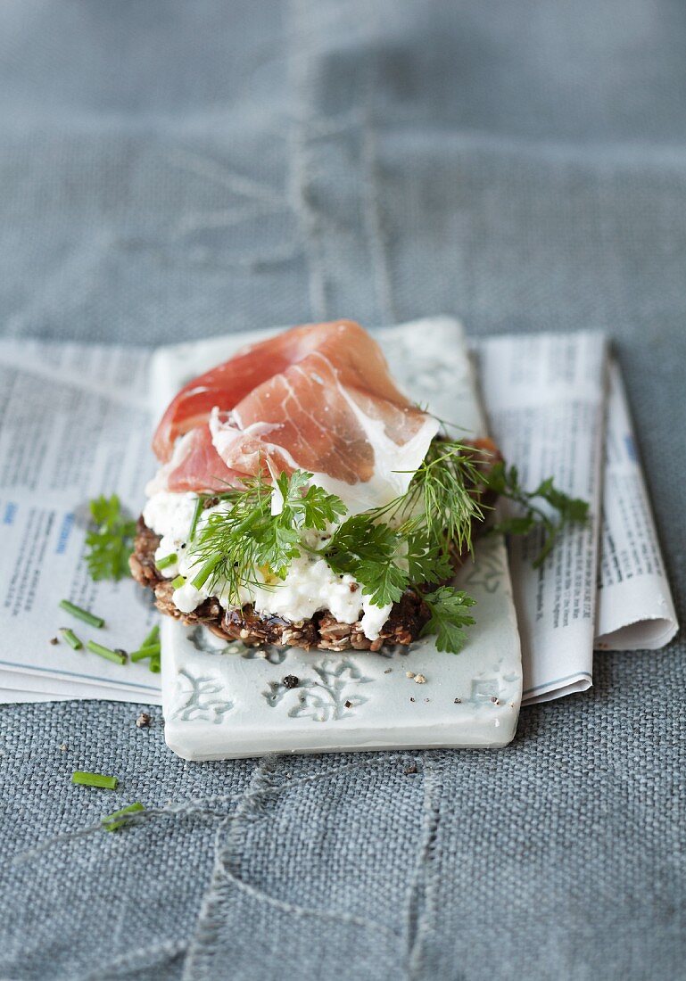 Vollkornbrot mit Hüttenkäse, Kräutern und Parmaschinken