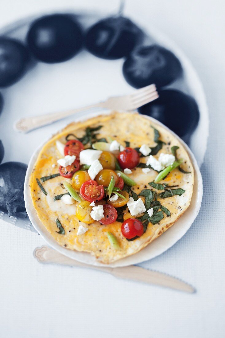 An omelette with tomatoes, goat's cream cheese and basil