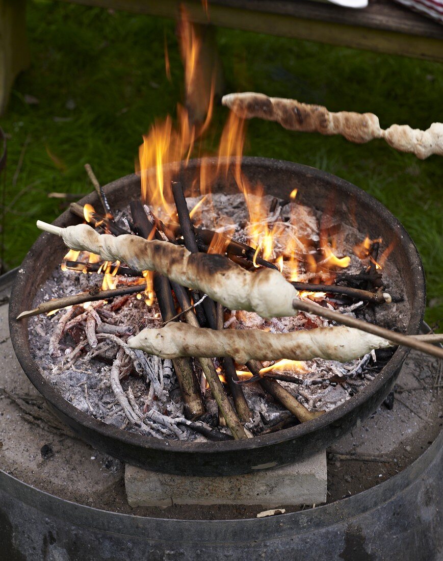 Stick bread being grilled on an open fire