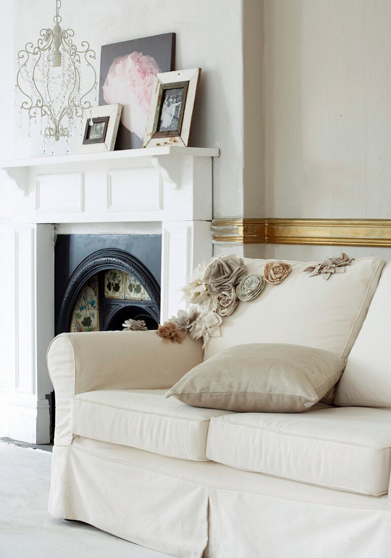 White upholstered sofa next to an open fireplace in a traditional room