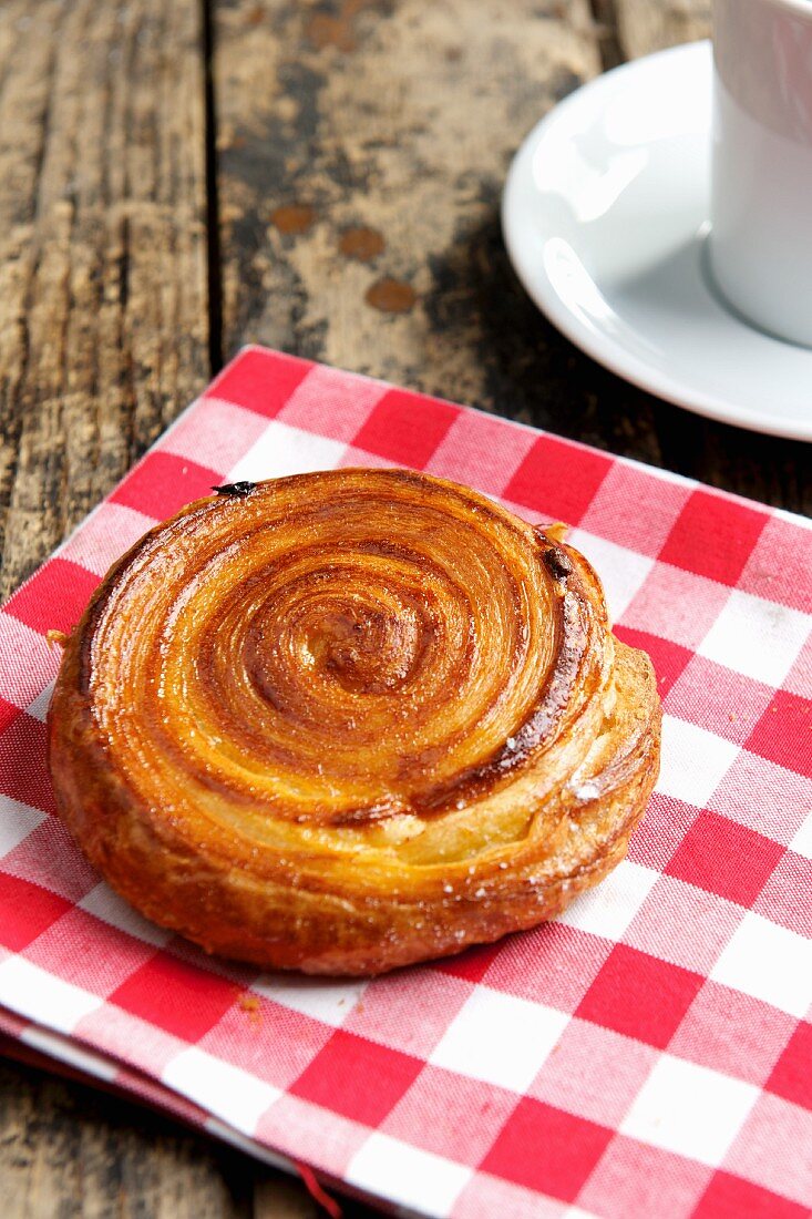 A puff pastry spiral on a checked cloth