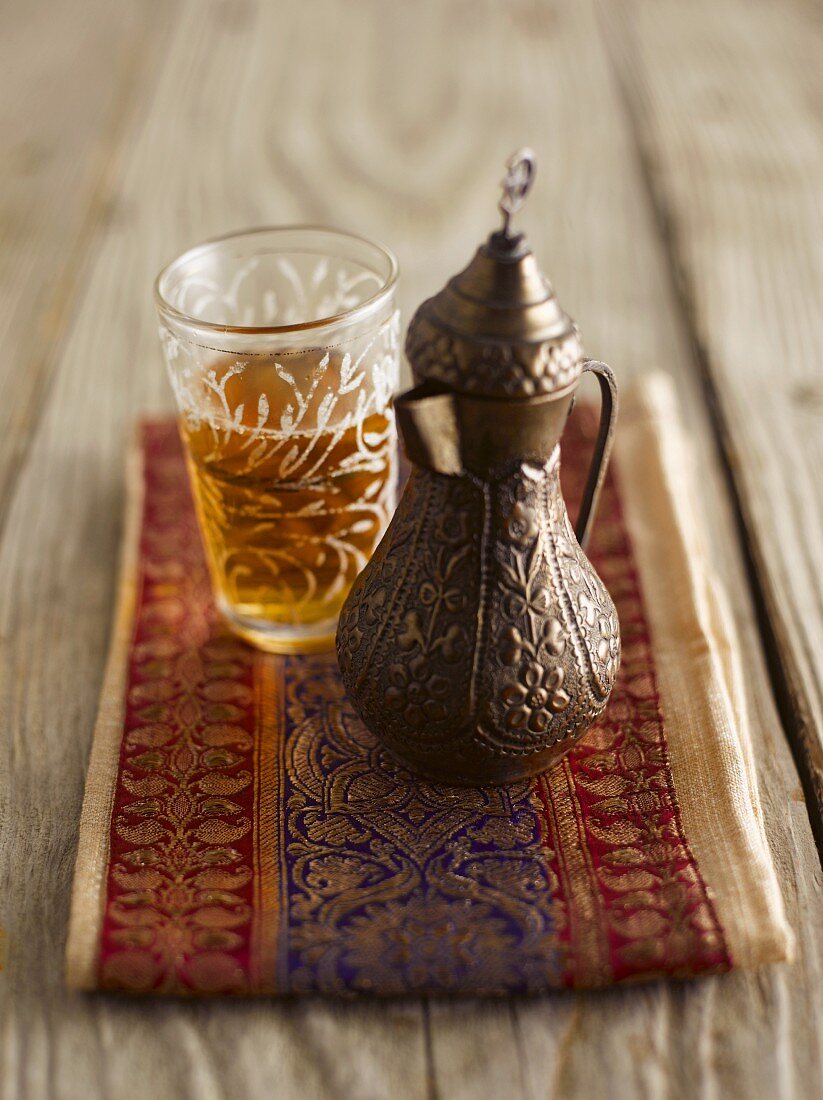 Black tea in an oriental jug and a glass