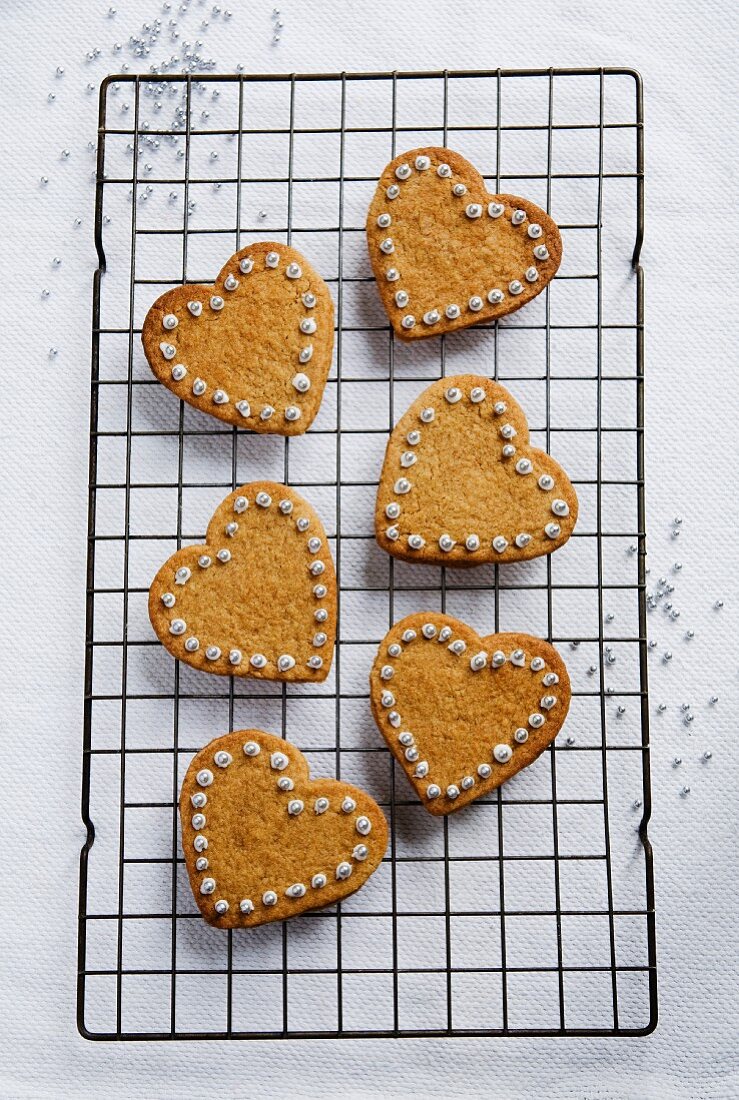 Decorated heart-shaped cinnamon biscuits on a wire rack