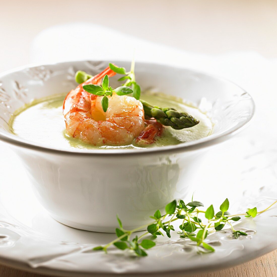 Green asparagus soup with fried prawns