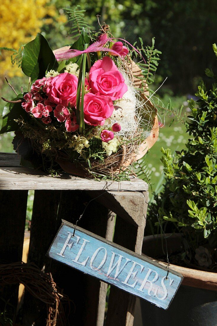 Frühlingsstrauss mit Rosen und Fresien auf Naturkranz gebunden