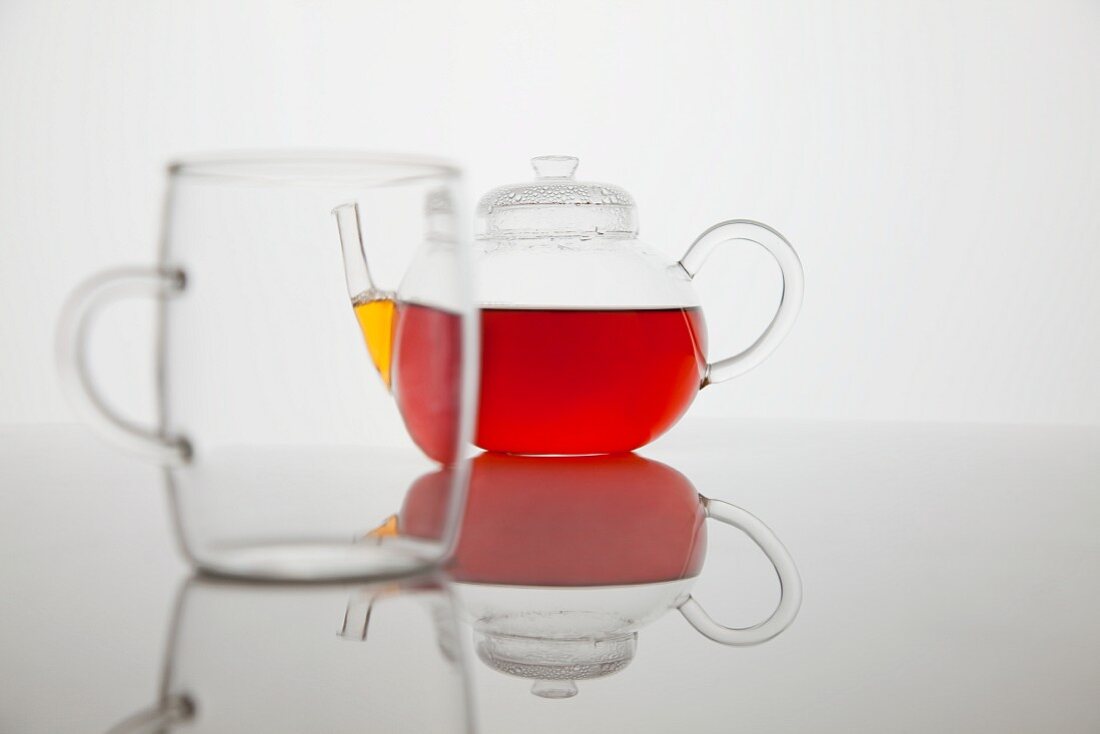 Tea in a glass jug with an empty glass in the foreground