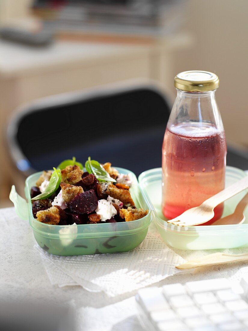 Beetroot salad with croutons and a bottle of juice for lunch
