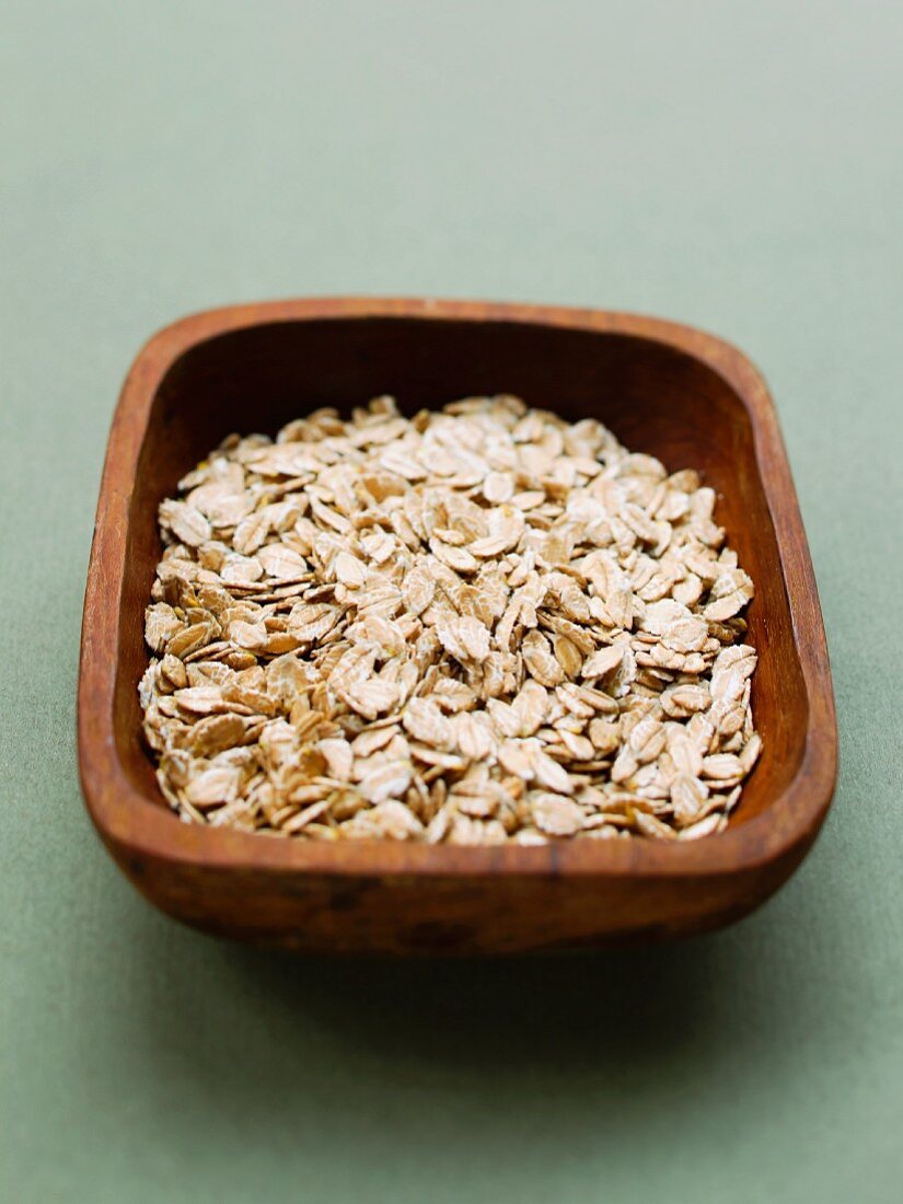 A wooden bowl of spelt flakes