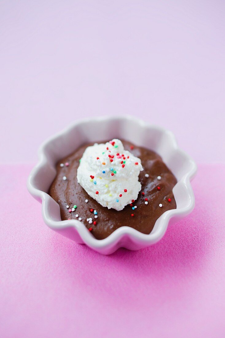 Schokoladenpudding mit Sahne und bunten Zuckerperlen