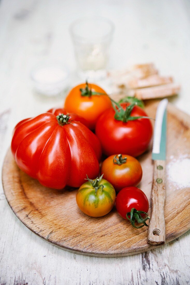 Various tomatoes on a round wooden board