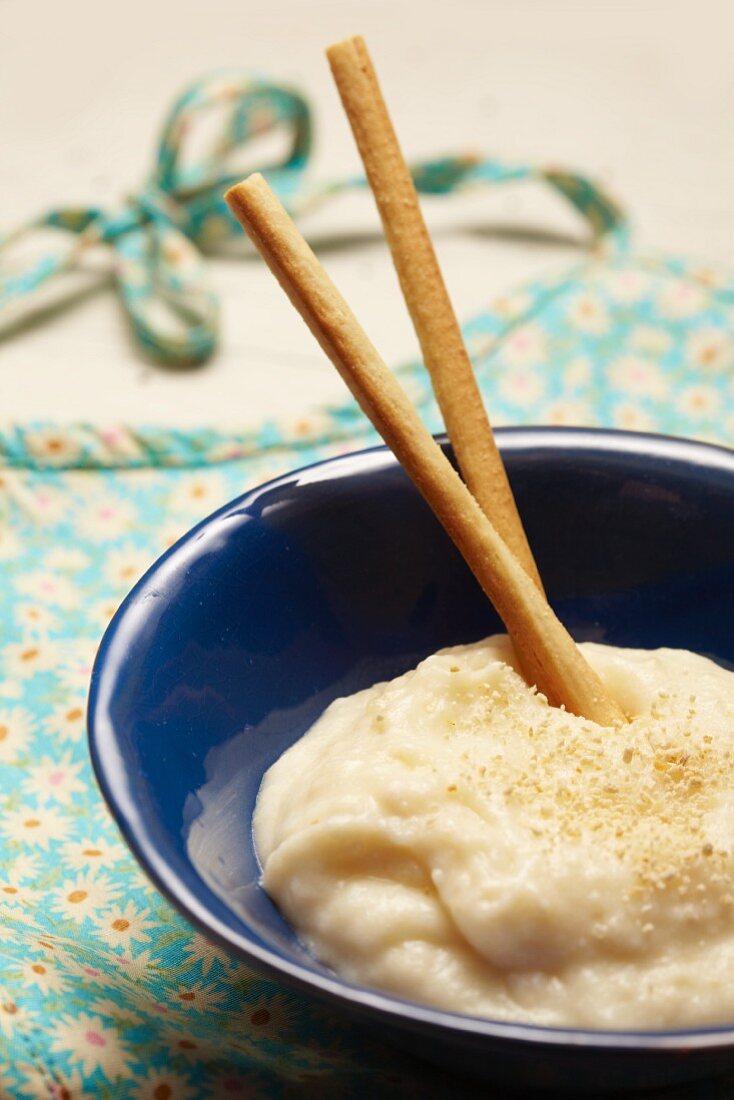 Babybrei mit Mandeln in Schälchen auf Lätzchen