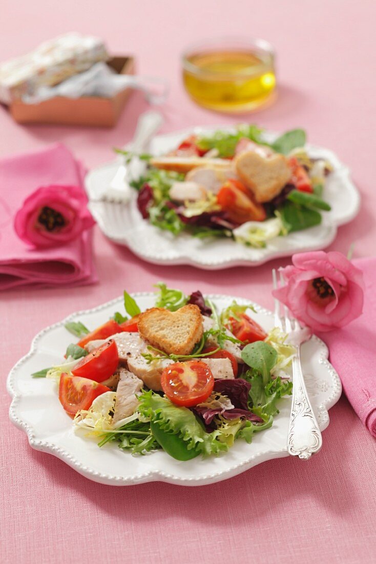 Blattsalat mit Kirschtomaten, gegrillter Hähnchenbrust und herzförmigen Croûtons