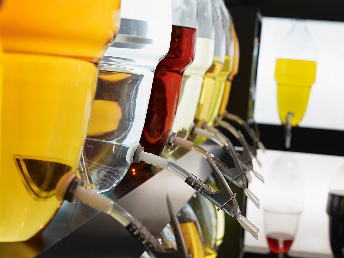 Reihe von Glasbehältern mit Spirituosen: Single Malt, Gin, Brandy, Williamsbirne