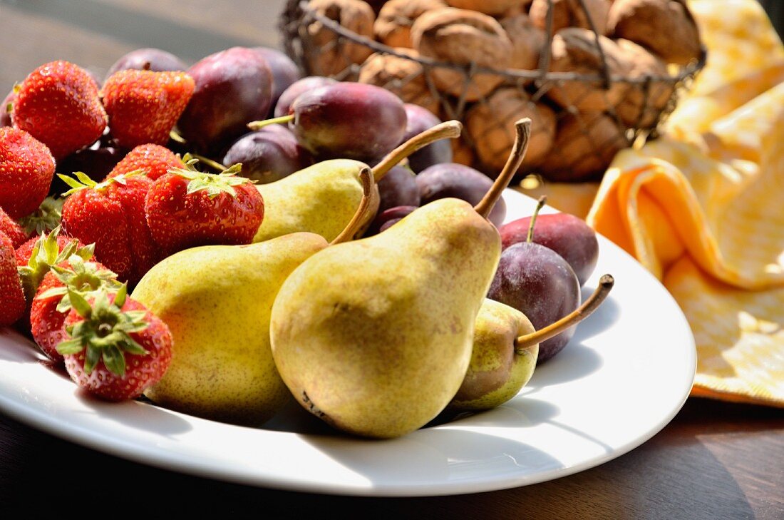 Strawberries, pears and plums on a plate