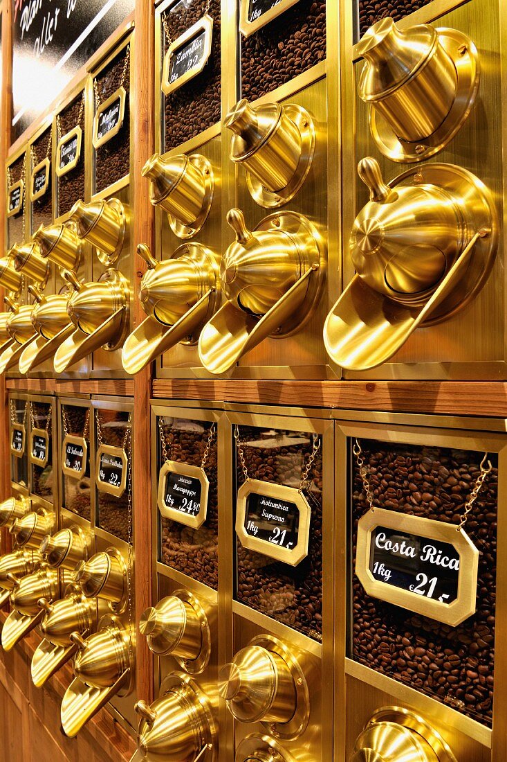 Row of traditional coffee dispensers with coffee beans