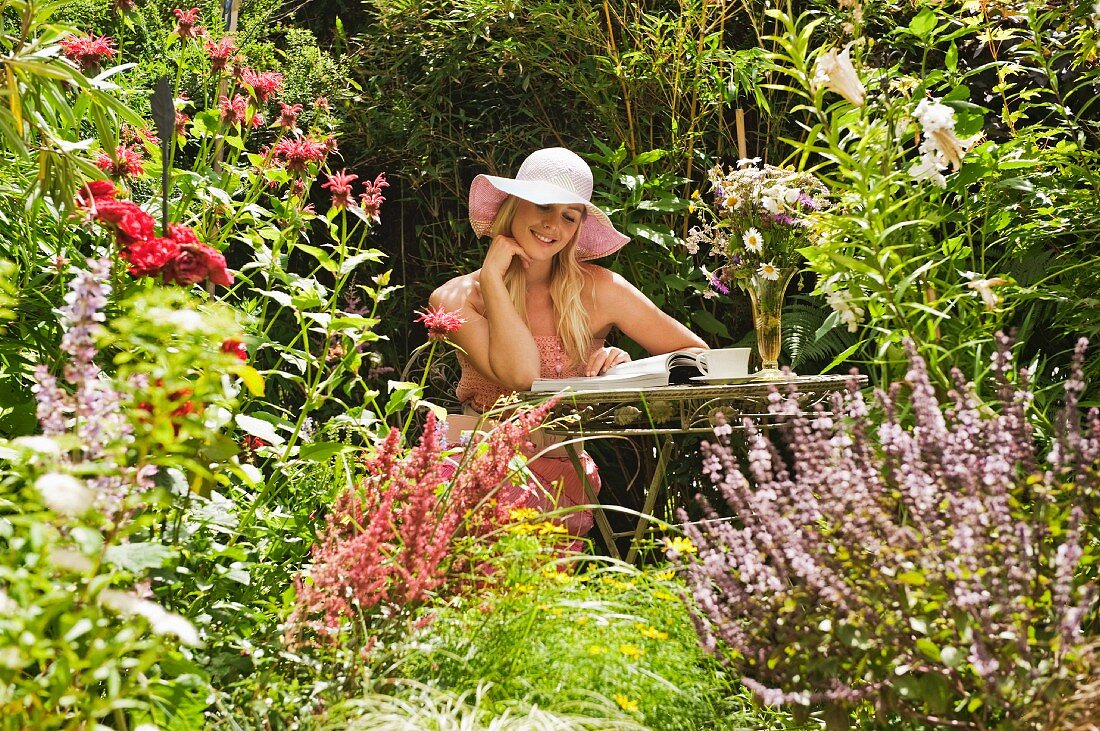 Frau liest ein Buch im Garten