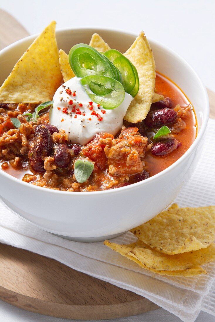 Chili con carne with sour cream and tortilla chips