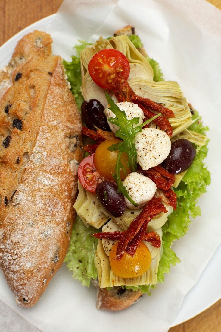 A mozzarella, tomato, artichoke and olive sandwich