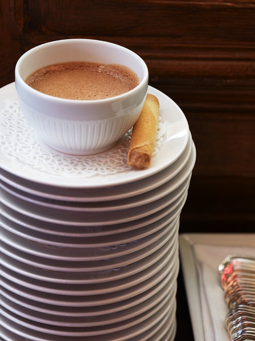 A cup of cocoa with a chocolate wafer