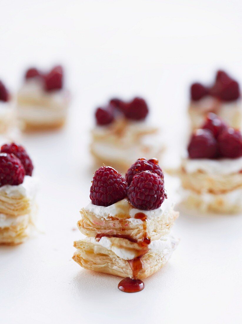 Bite-sized puff pastries with cream, caramel and raspberries
