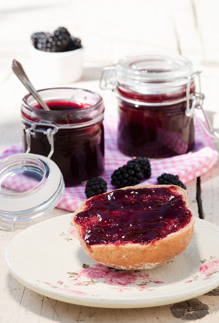 A bread roll spread with blackberry jelly