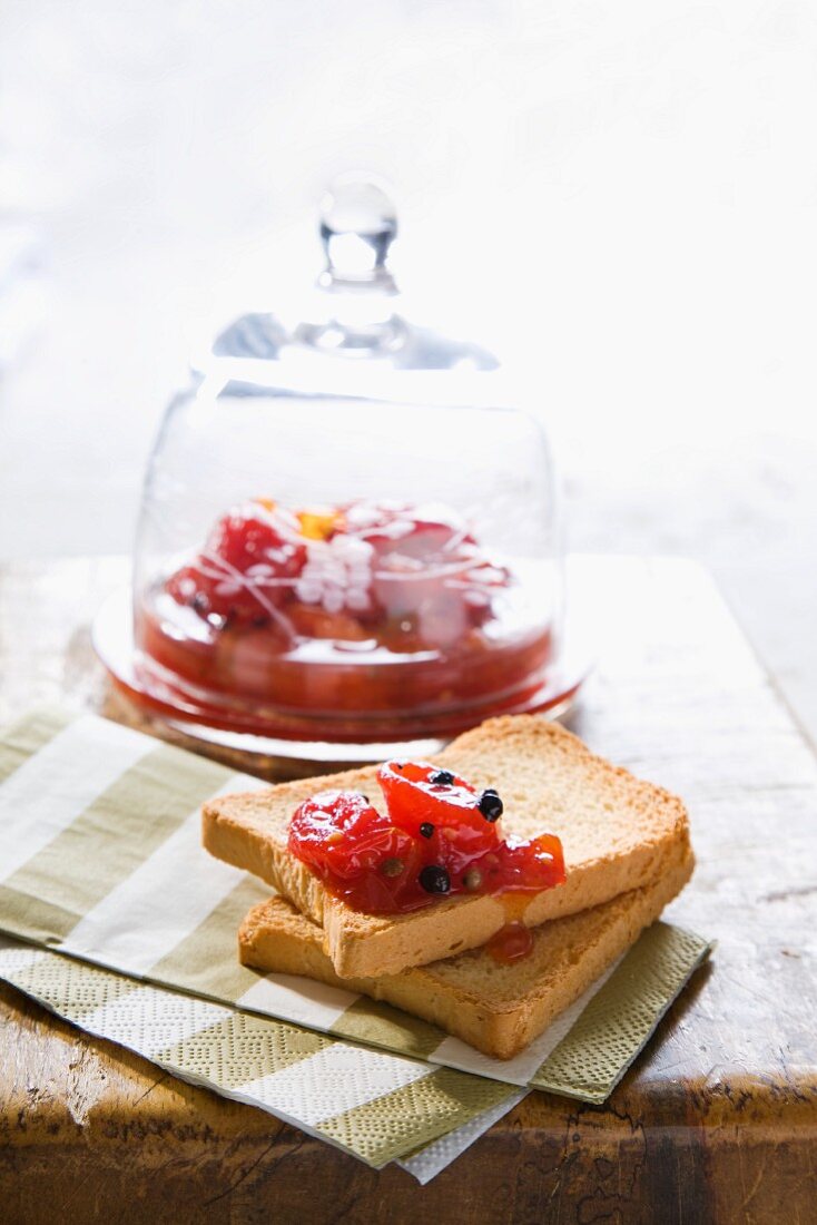 Preserved cherry tomatoes with black pepper on rusks