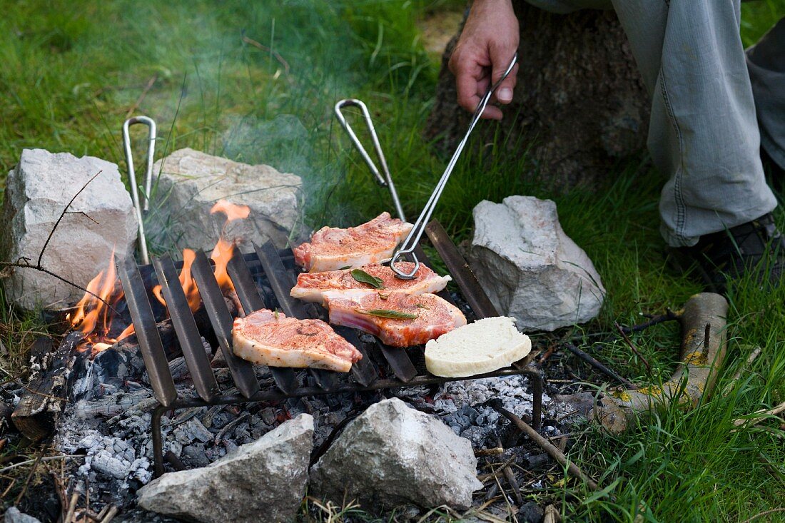 Meat being barbecued on a campfire