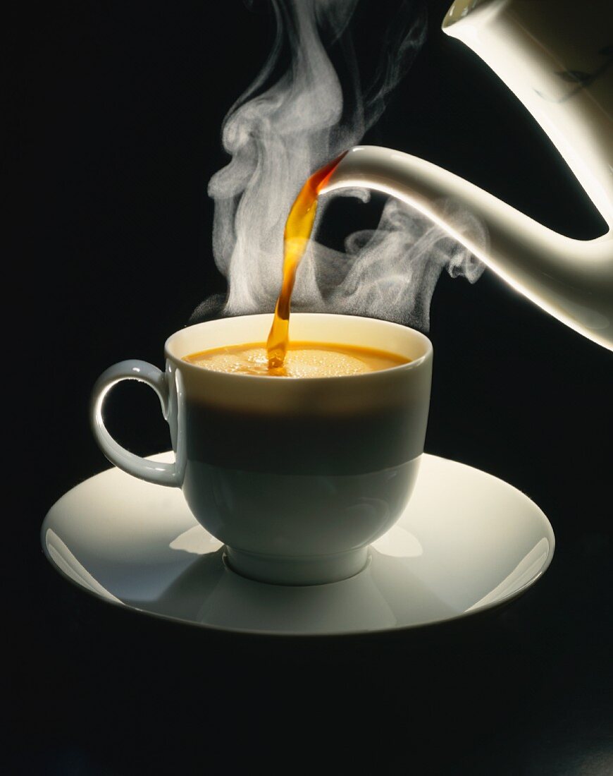 Eine Tasse Kaffee einschenken, schwarzer Hintergrund