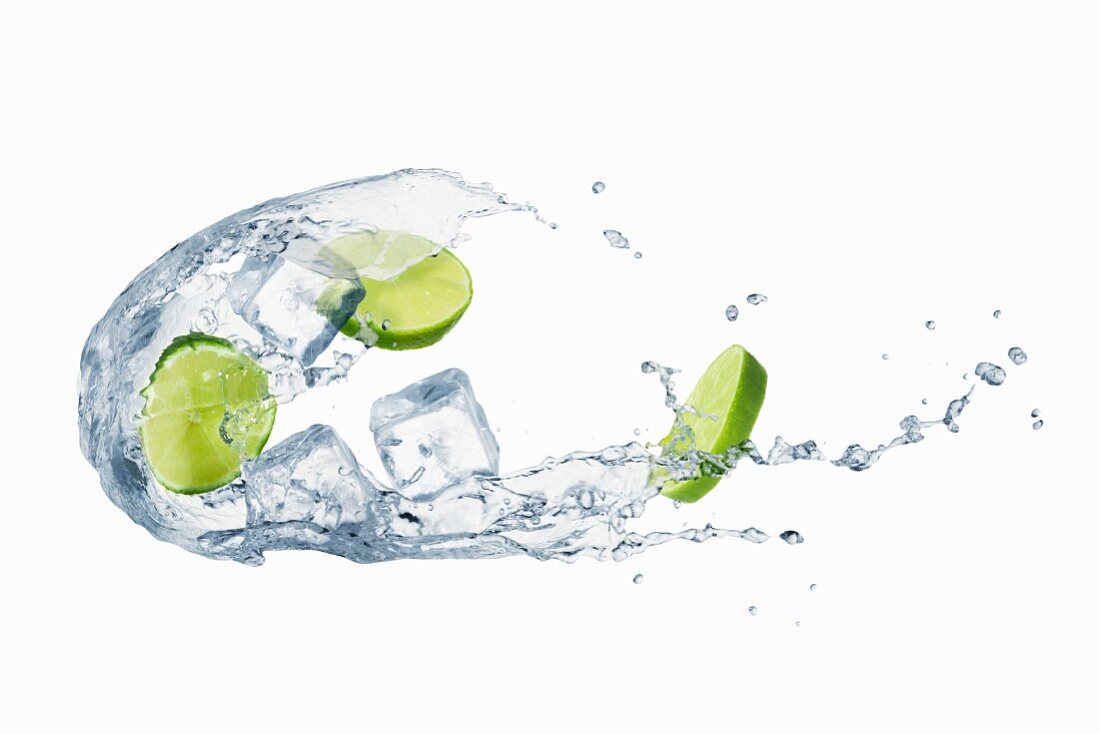 A splash of water with limes and ice cubes