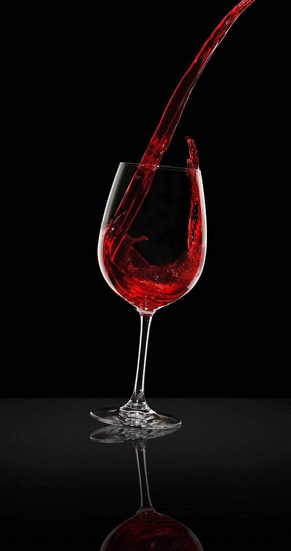 Red wine being poured from a bottle into a glass
