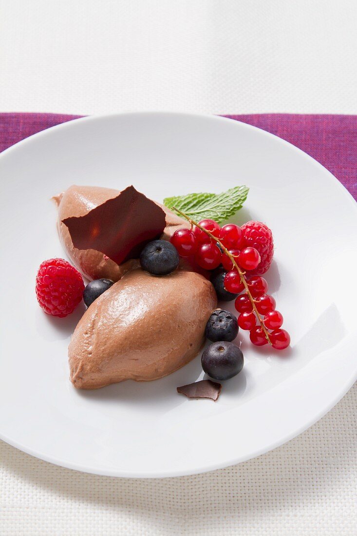 Mousse au chocolat garnished with fresh berries and mint