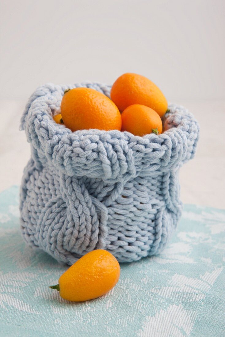 Knitted bag filled with kumquats