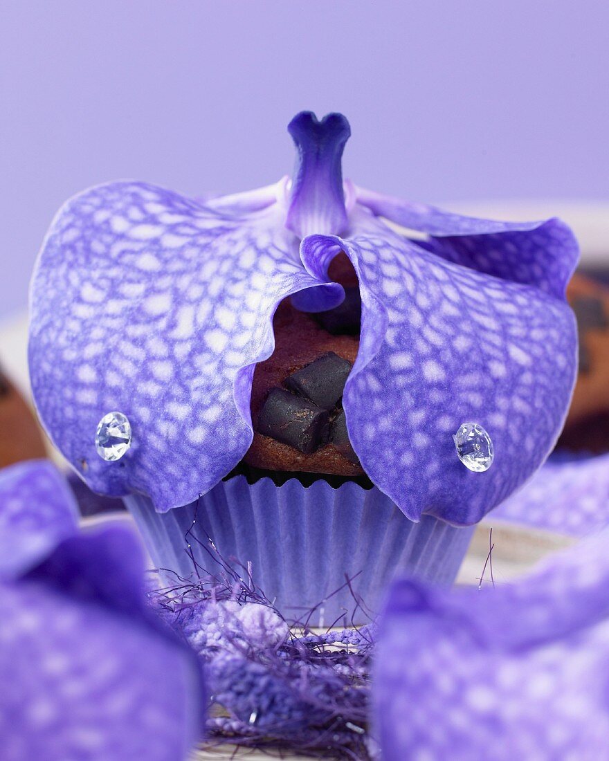 A muffin topped with an orchid flower