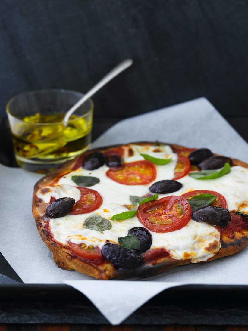 Pizza mit Mozzarella, Tomaten und Oliven