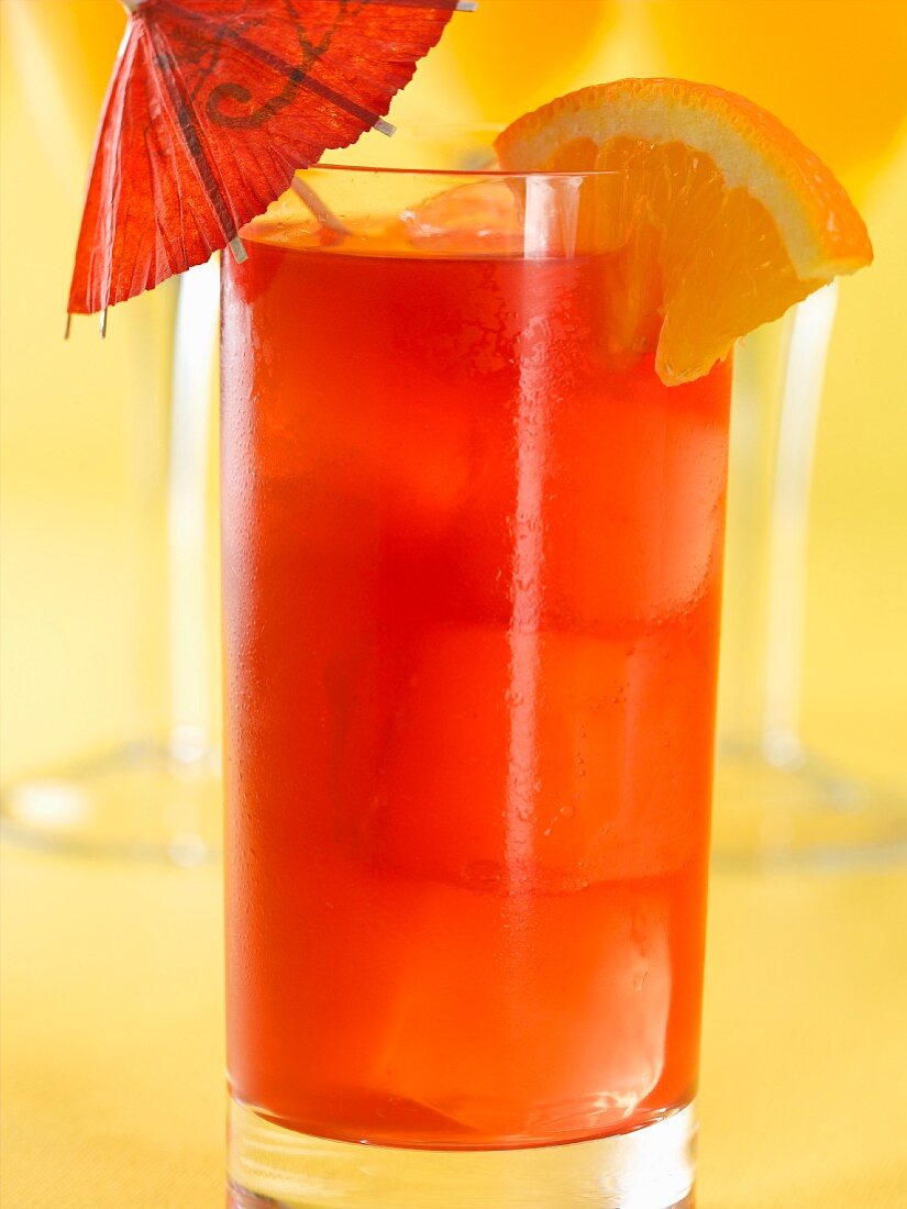 Singapore Sling Cocktail mit Orange und Cocktailschirmchen