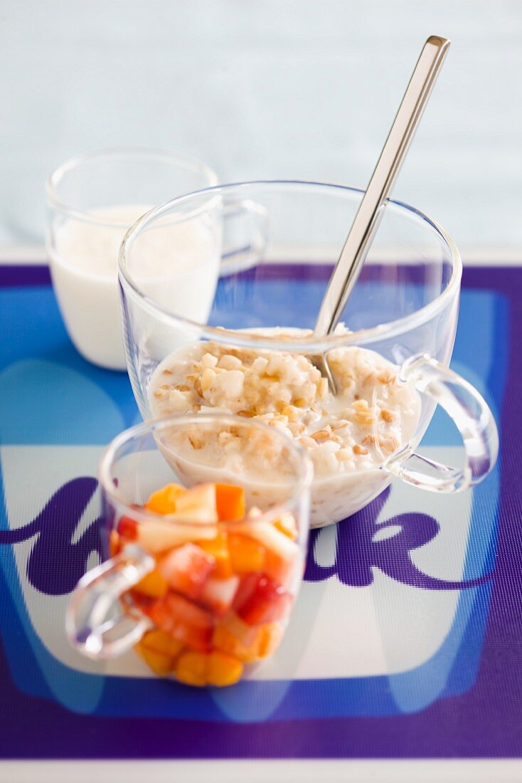 Porridge in Glastasse daneben Früchte & Milch als Zutaten