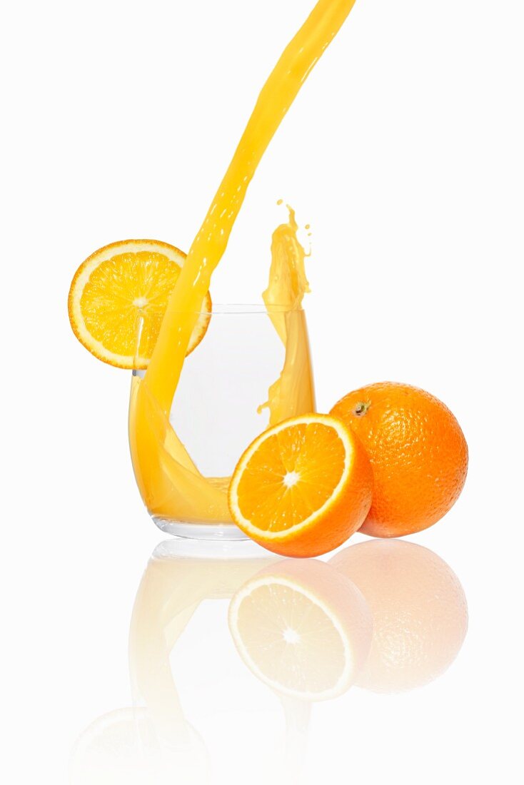Orangensaft in ein Glas gießen
