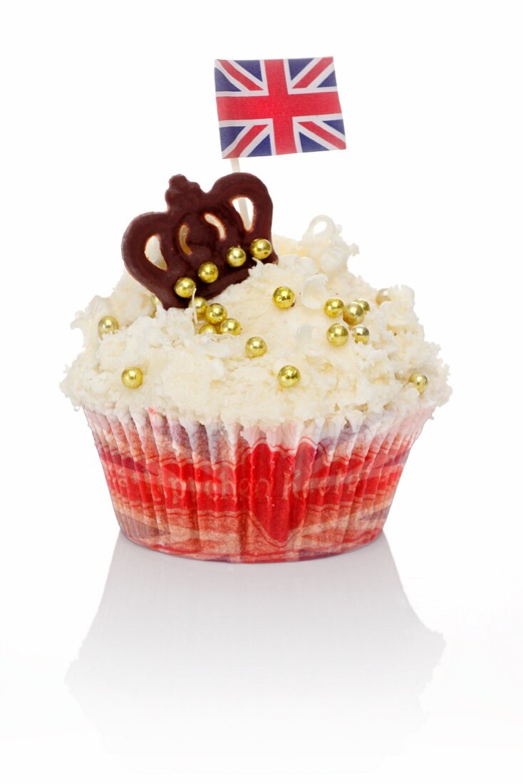A cupcake decorated with golden beans, a chocolate crown and a Union Jack