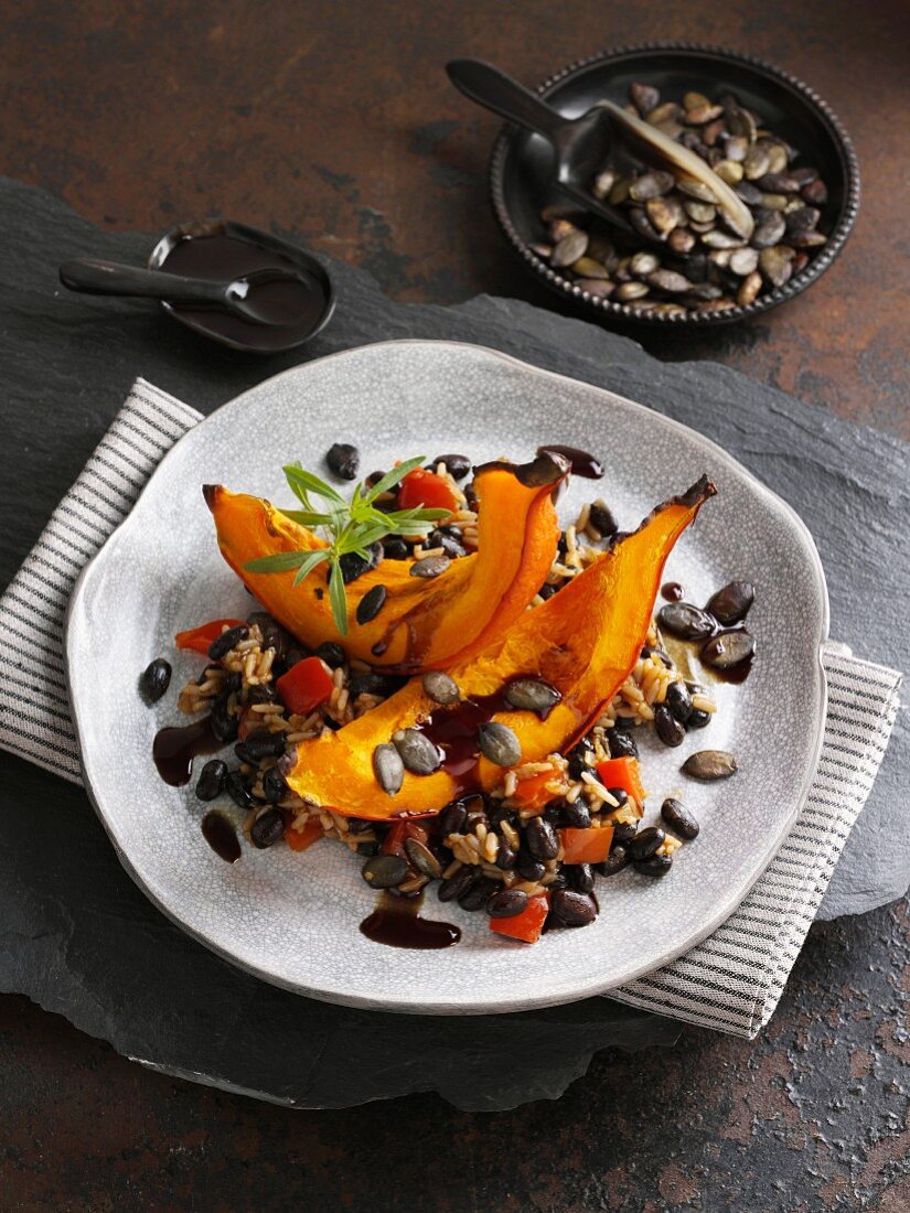 Roasted pumpkin on a bed of black beans with rice