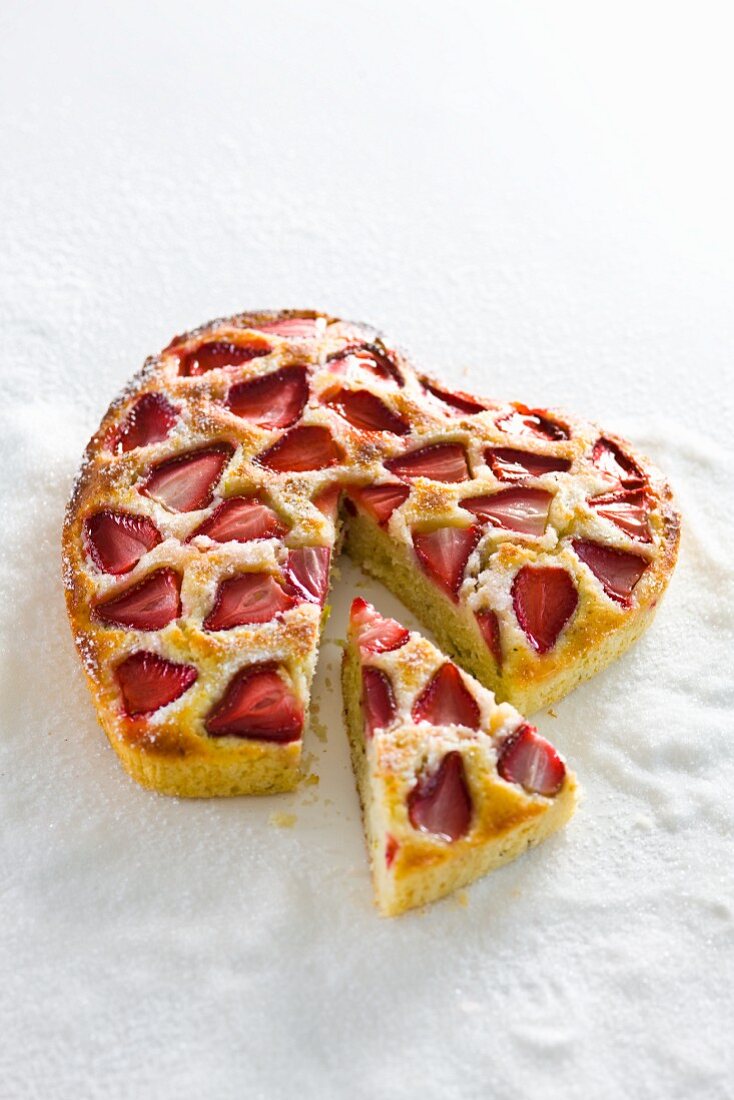 A heart-shaped cake with strawberries and lemongrass