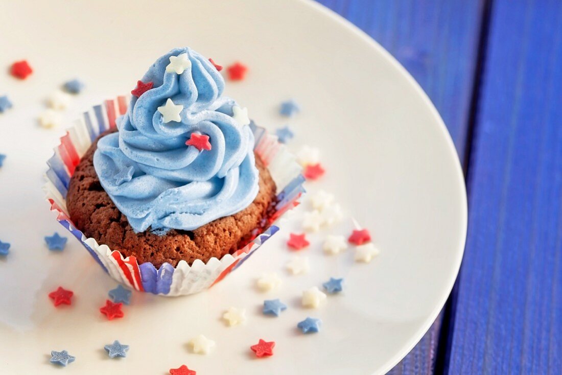 A chocolate cupcake top with blue cream